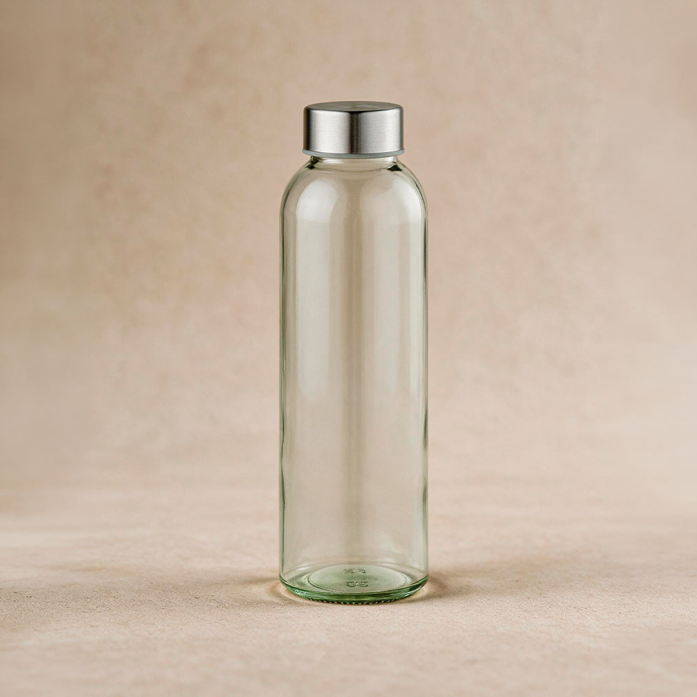Lima Glass Bottle 530ml with silver lid styled on a warm neutral surface